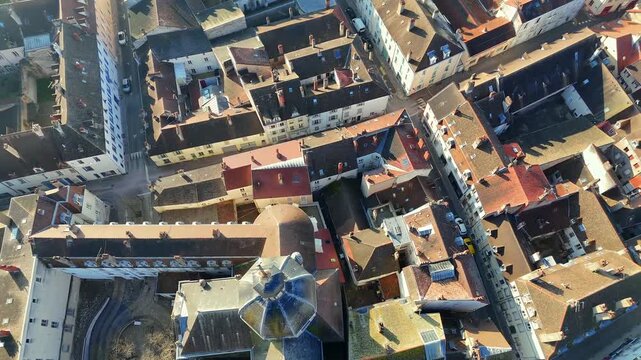 Vertical aerial perspective capturing dense historic district with terracotta tiled roofs winding streets and geometric urban layout in bright sunlight
