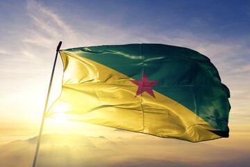 French Guiana flag textile cloth fabric waving on the top sunrise mist fog