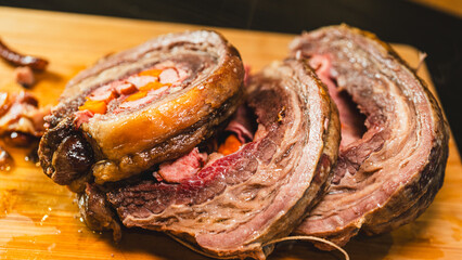 Juicy stuffed beef ribs with calabrese sausage, bacon and vegetables. Golden brown and perfectly cooked, tied with twine. Ideal for gourmet menus and meat promotions.