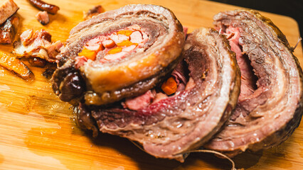 Juicy stuffed beef ribs with calabrese sausage, bacon and vegetables. Golden brown and perfectly cooked, tied with twine. Ideal for gourmet menus and meat promotions.
