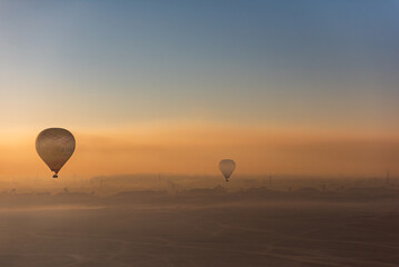 Hot air balloons in the sunrise misty sky