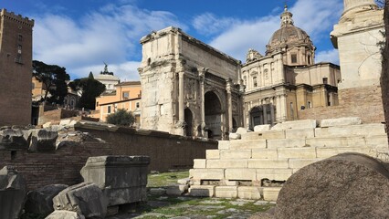 Rome, Italy &ndash; 13 January 2025. The Arch of Septimius Severus rises among Roman Forum ruins with Santi Luca e Martina&rsquo;s dome under a bright winter sky.