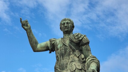 Rome, Italy &ndash; 13 January 2025. Statue of Emperor Trajan in decorated armor, pointing upward with his right hand beneath a clear blue sky.