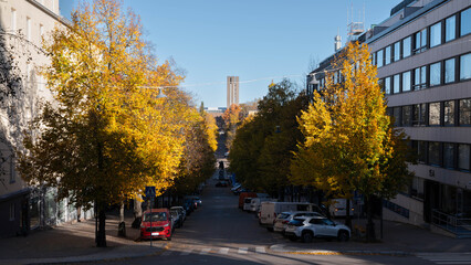 Urban street in Finland with yellow autumn trees and Nordic architecture