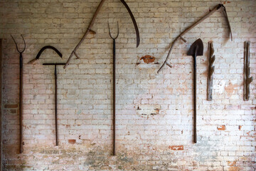 Traditional farm tools on a rustic barn wall reflect the pride, resilience and sustainability at the heart of British farms and farmers