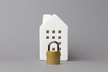White house model with a golden padlock in front, symbolizing home safety and security, representing balance and protection in life. copy space
