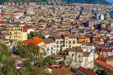 Obraz premium Salerno, Italy. Aerial view of a vibrant urban landscape showcasing colorful buildings terracotta rooftops and lush greenery illustrating the charm of a coastal city environment