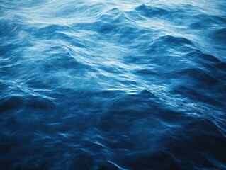 Obraz premium Deep blue ocean waves are gently rolling and creating beautiful water patterns.