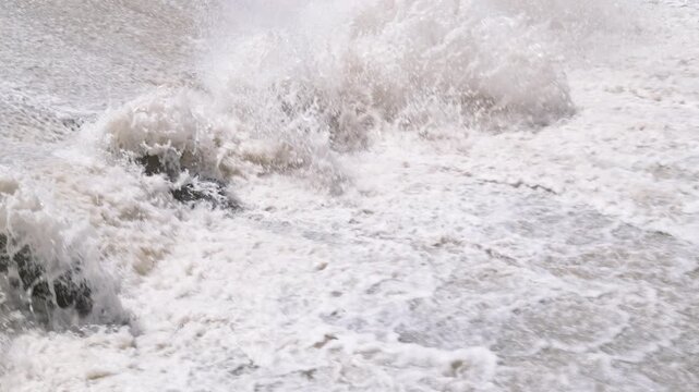 row of chute dentate blocks in concrete water spillway channel slope slowing down splashing flow of water running down.