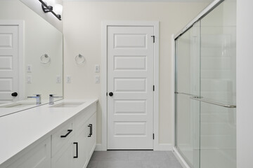 Bathroom with a white door and a glass shower
