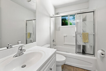 Bathroom with a white toilet, sink, and shower stall