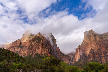 Majestic mountains shrouded in mist with a waterfall.