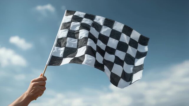 Victory Flag Waving at the Finish Line &ndash; Motorsport Checkered Flag Against Blue Sky