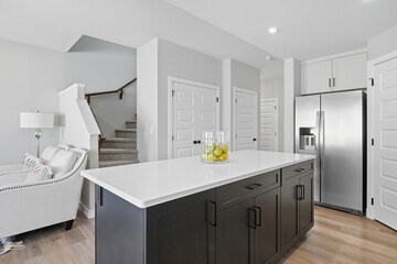 Kitchen with a white island and a silver refrigerator