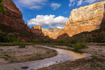 River flows through Zion National Park canyon at sunset.