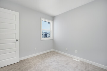 White bedroom with a window and a door