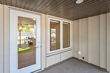 White door with a glass window is open to a porch