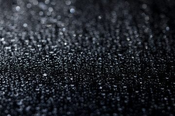 water drops on glass in close-up. abstract dark background with beautiful bokeh. Mockup for your logo. horizontal wallpaper or web banner.