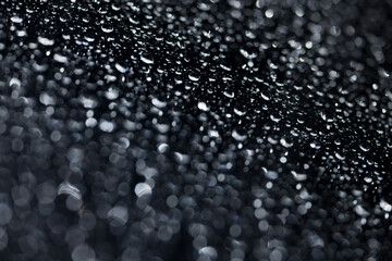 water drops on glass in close-up. abstract dark background with beautiful bokeh. Mockup for your logo. horizontal wallpaper or web banner.