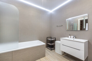 Modern bathroom design featuring a sleek tub, minimalist storage, and elegant lighting in a contemporary home setting
