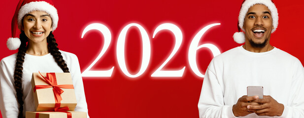 Two cheerful individuals pose with presents, wearing Santa hats. The background features a bright...