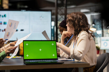 Diverse company associates using isolated mockup for performance metrics, setting business objectives with data insights. Corporate feminism and teamwork in office environment.