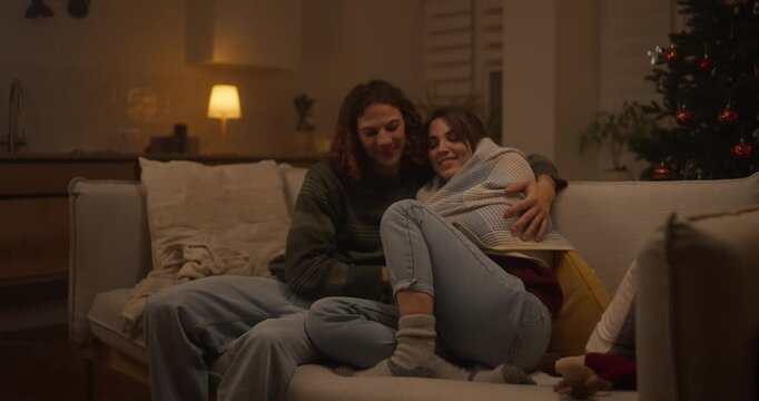 Cozy evening with friends indoors while wrapped in blankets during the holiday season