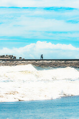 九十九里浜の夏空と防波堤を歩く人々