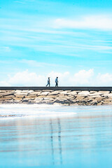 九十九里浜の夏空と防波堤を歩く人々