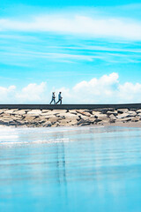 九十九里浜の夏空と防波堤を歩く人々
