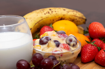 Fresh Fruit Salad with Milk, Grapes, Strawberries, Bananas, and Oranges. Healthy Breakfast Concept