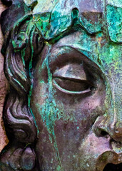 Close-up of a weathered statue face with closed eyes
