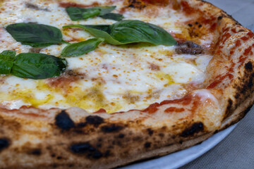 Eating of fresh baked Naples pizza dish in italian pizzeria restaurant, close up