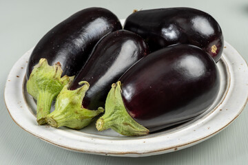 Group of small garden-fresh organic eggplants vegetables on table