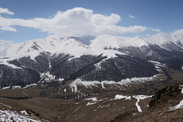 Mountain valley with dark bare forest and snow-capped peaks, Lori, Armenia