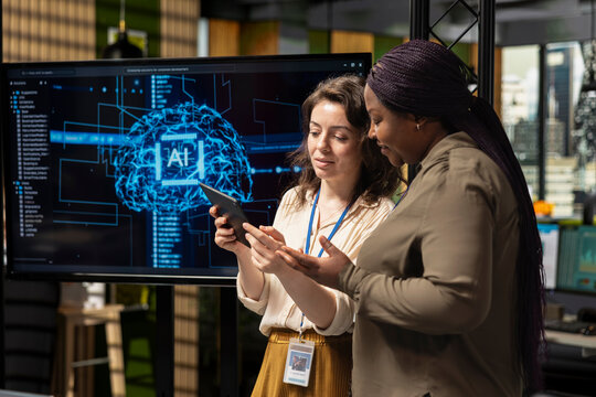 Diverse management staff reviewing advanced AI algorithms and predictive models to enhance organizational growth strategy, employee performance and long term company objectives.