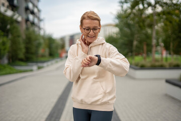 Active woman checking pulse and smartwatch outdoors