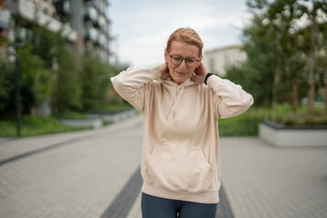 Naklejka premium Woman experiencing neck pain holding her neck