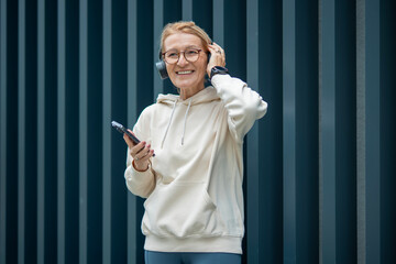Mature woman smiling enjoying music with wireless headphones