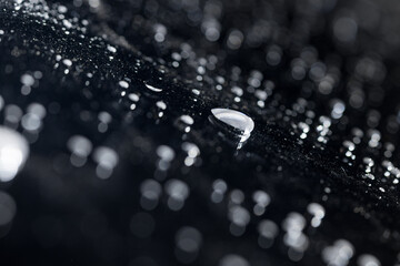 raindrops on a dark background.water drops on glass in close-up. Abstract dark background. Mockup for your logo. horizontal wallpaper or web banner.