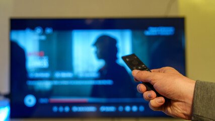 22-10-2025 Coventry, Uk. Hand using remote control watching streaming content on television