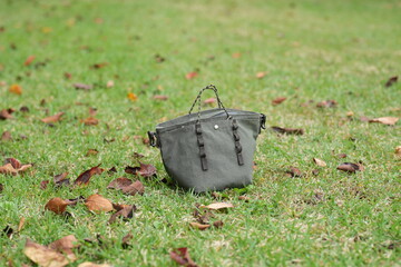 A small purse is sitting on the grass in a park
