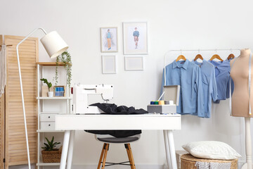 Interior of atelier with tailor's workplace, mannequin and clothes rack