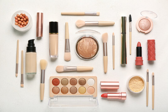 Composition with different makeup brushes and cosmetic products on white background