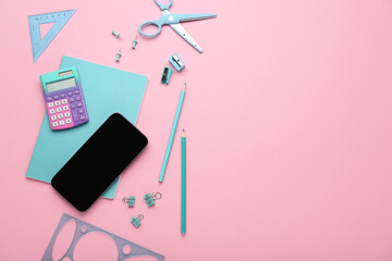 Set of school stationery and mobile phone on pink background