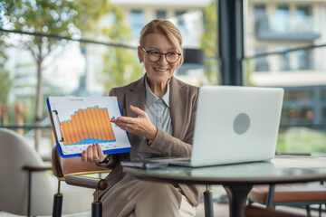Businesswoman presenting sales monthly chart during online meeting