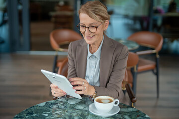 Mature businesswoman using tablet for remote work