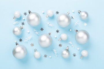 Grey Christmas balls with decor on color background, top view