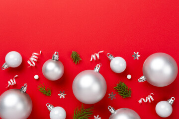 Grey Christmas balls with decor on color background, top view