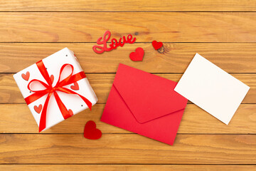 Valentine's Day composition with gifts and red roses on wooden background, top view